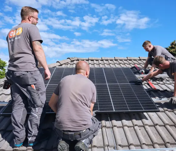 evm Handwerker montieren eine Solaranlage auf ein Dach.
