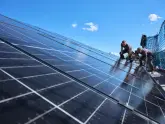 evm Handwerker montieren eine Solaranlage auf ein Dach.