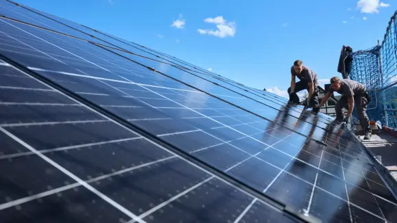 evm Handwerker montieren eine Solaranlage auf ein Dach.