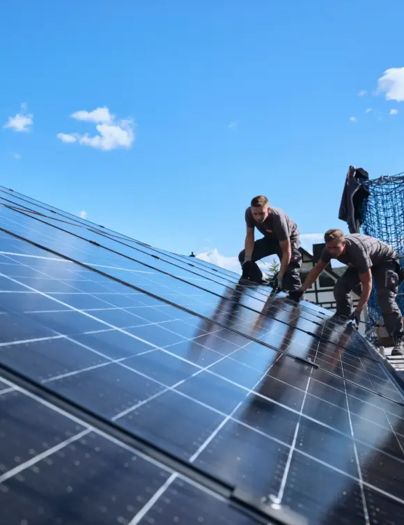 evm Handwerker montieren eine Solaranlage auf ein Dach.