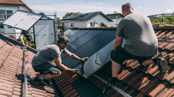 Handwerker installieren PV-Anlage auf Dach