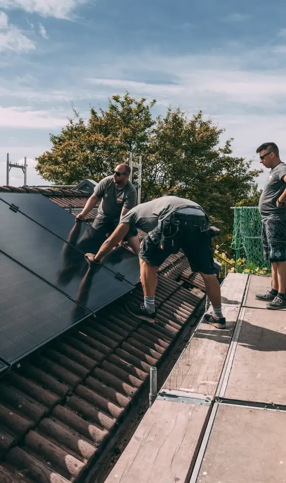 evm Handwerker montieren eine Solaranlage auf ein Dach.