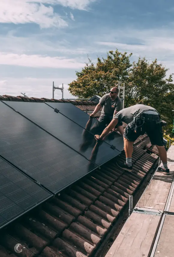 evm Handwerker montieren eine Solaranlage auf ein Dach.