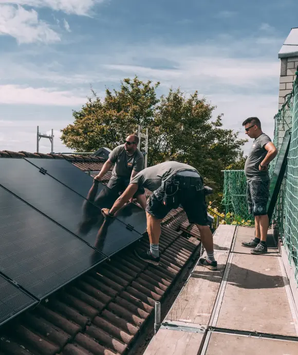 evm Handwerker montieren eine Solaranlage auf ein Dach.