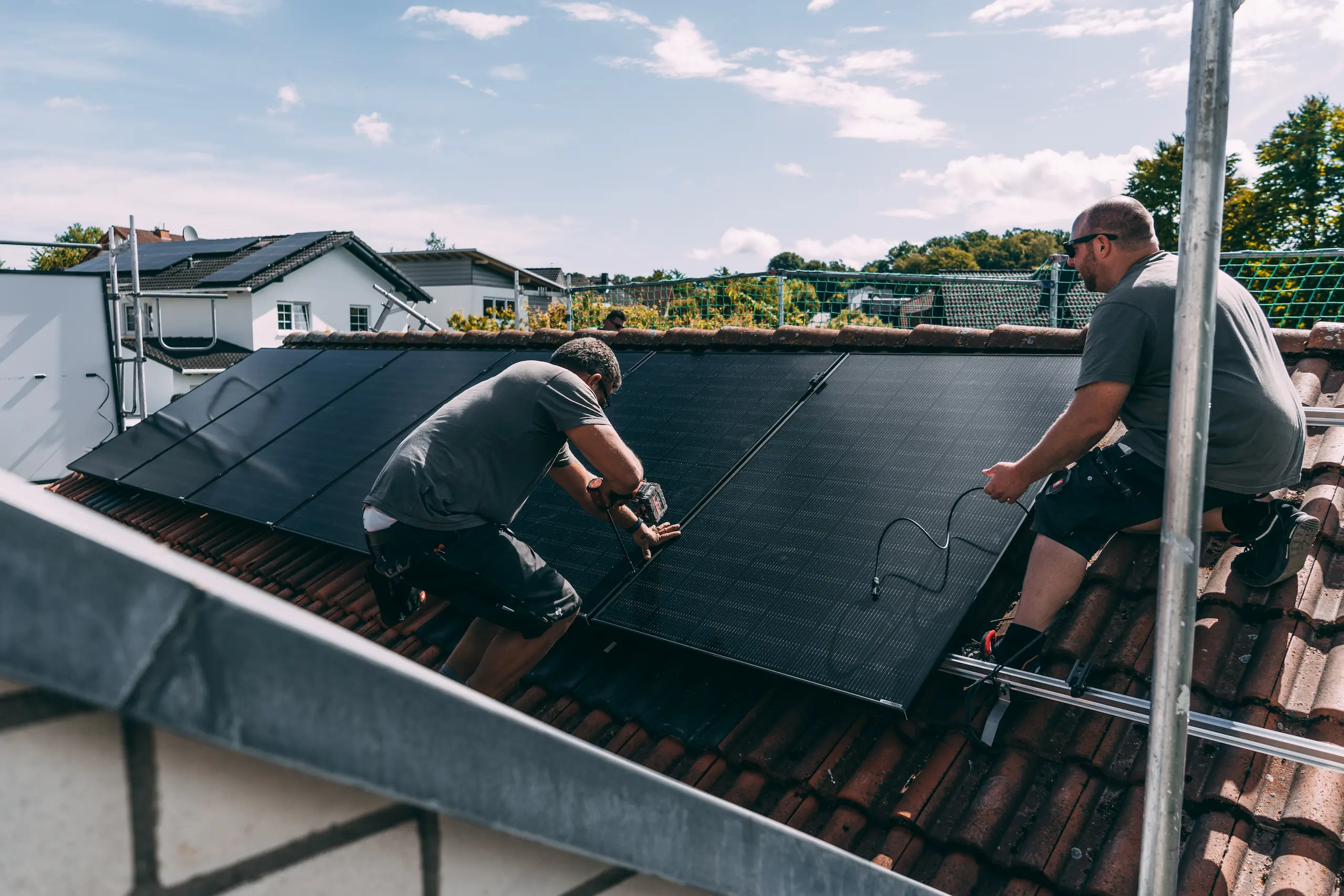 evm Handwerker montieren eine Solaranlage auf ein Dach.
