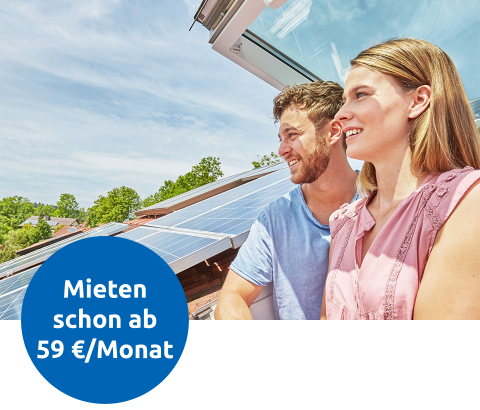 Ein Paar steht in einem Dachfenster und schaut raus. Auf dem Dach befindet sich eine Solaranlage. Daneben ein blauer Kreis mit Aufschrift "Mieten schon ab 59€ / Monat".