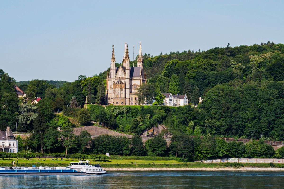 Apollinariskirche in Remagen am Rhein, Deutschland Apollinariskirche in Remagen auf einer Anhöhe über dem Rhein. Die neugotische Kirche mit ihren schlanken Türmen ist von dicht bewaldeten Hängen umgeben, im Vordergrund fließt der Rhein.