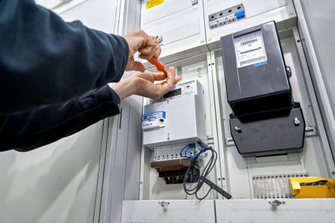 Eine Person arbeitet an einem Stromkasten