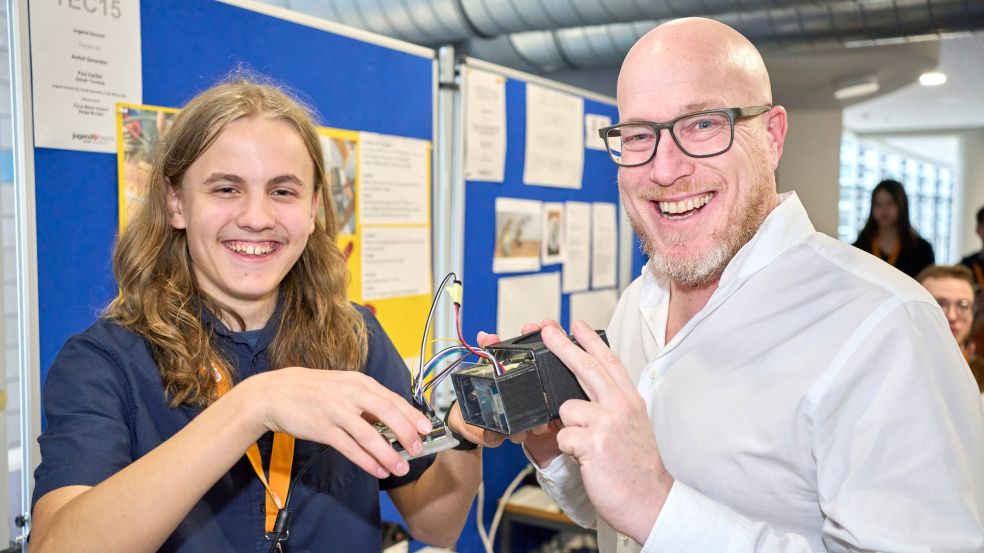Jonathan Baschek zeigt seine Datenbrille dem Wettbewerbspaten und evm-Unternehmenssprecher Christian Schröder beim Regionalentscheid „Jugend forscht“ an der Hochschule Koblenz
