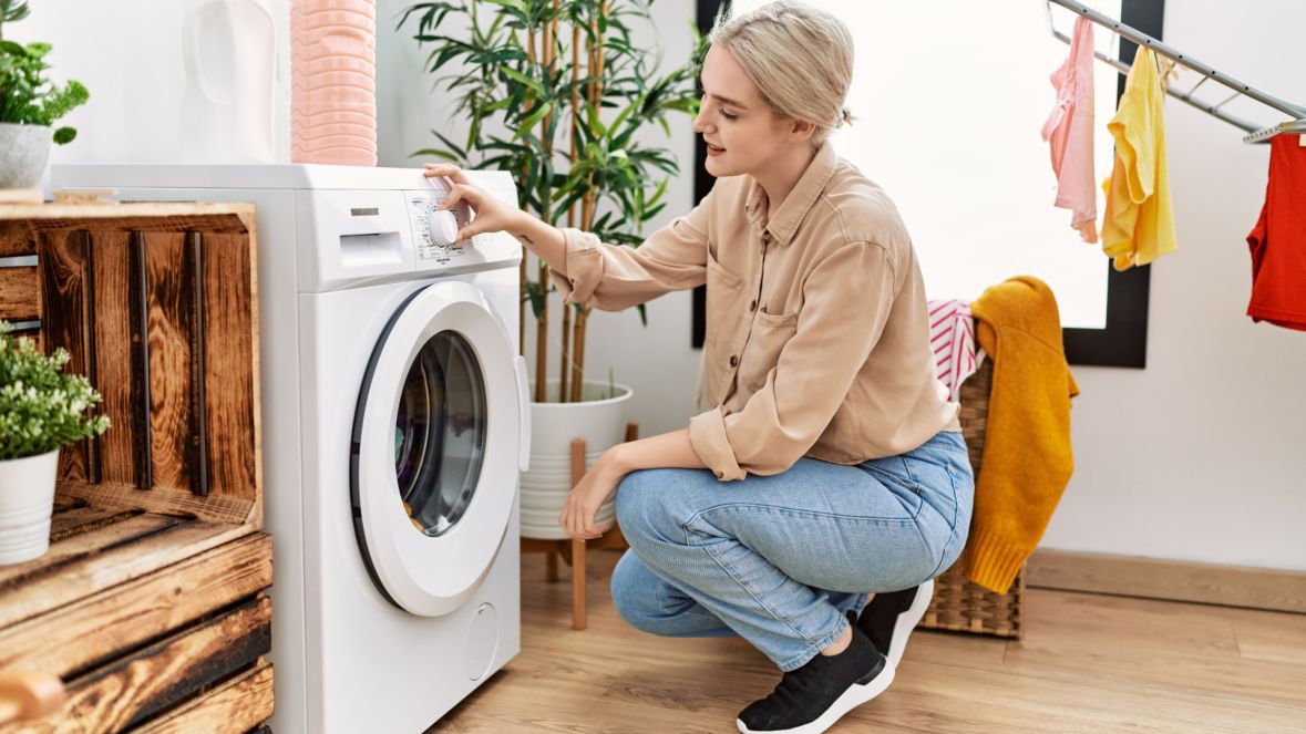 Young caucasian woman smiling confident washing clothes at laundry room