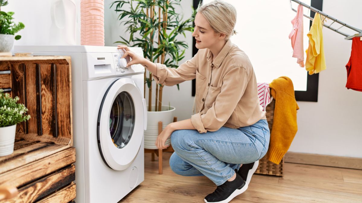 Young caucasian woman smiling confident washing clothes at laundry room