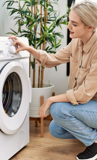 Young caucasian woman smiling confident washing clothes at laundry room