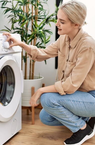 Young caucasian woman smiling confident washing clothes at laundry room Young caucasian woman smiling confident washing clothes at laundry room