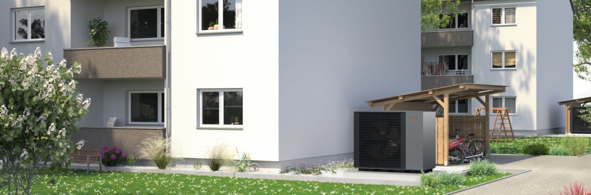 Stockfoto Mehrfamilienhäuser mit Photovoltaikanlage und Wärmepumpe als nachhaltige Energielösung.