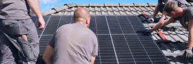 Evm Mitarbeiter montieren eine Solaranlage auf ein Dach