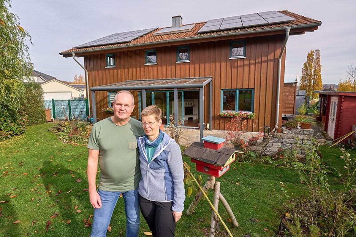 Familie Schneider steht vor ihrem Haus