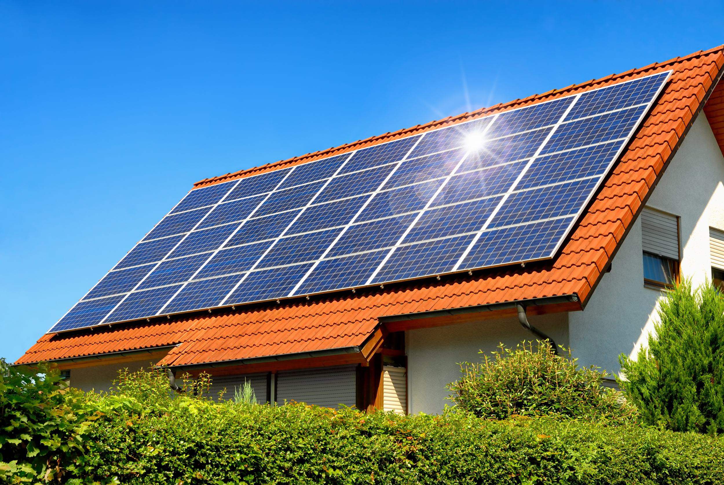 Solardach auf einem Einfamilienhaus reflektiert die Sonne Eine Hausdach mit Solarpanelen.