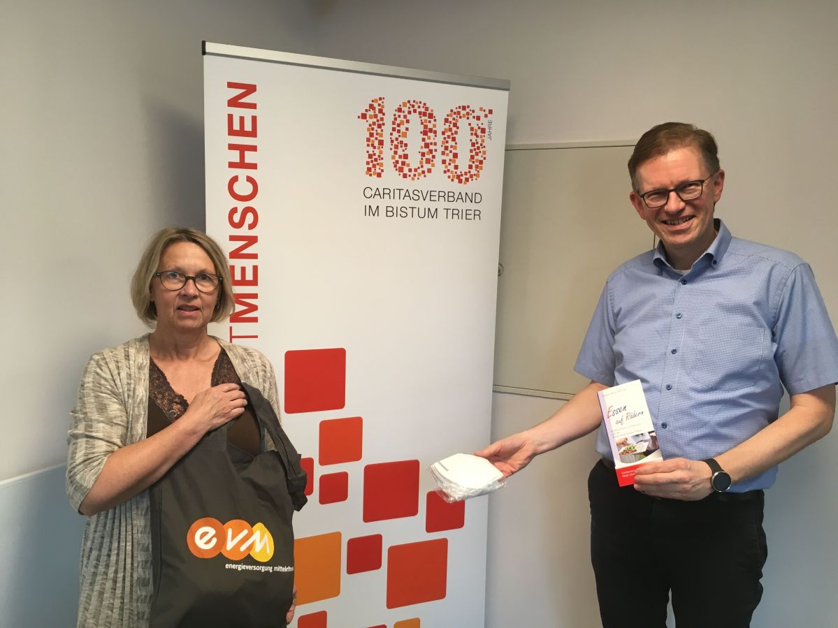 evm unterstützt Caritas Marcelo Peerenboom (rechts) überreichte Marita Bretz Schutzmasken. Außerdem stellt die evm ein Fahrzeug für Essen auf Rädern zur Verfügung.