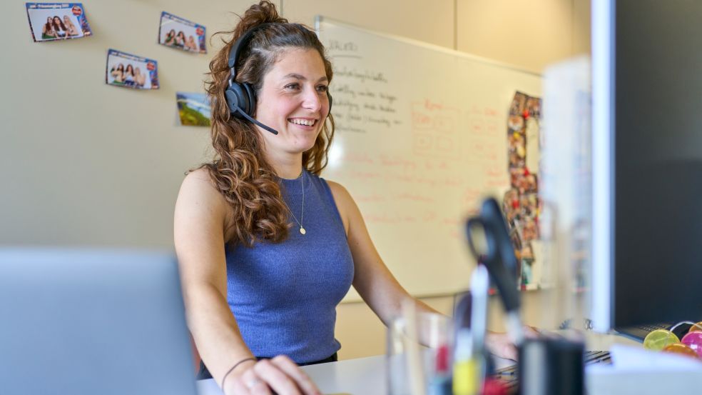 Energieeffizienz im Einsatz Valerie Schmitz am Arbeitsplatz: Mit Kopfhörern und Computermaus arbeitet sie konzentriert an ihrem Schreibtisch.