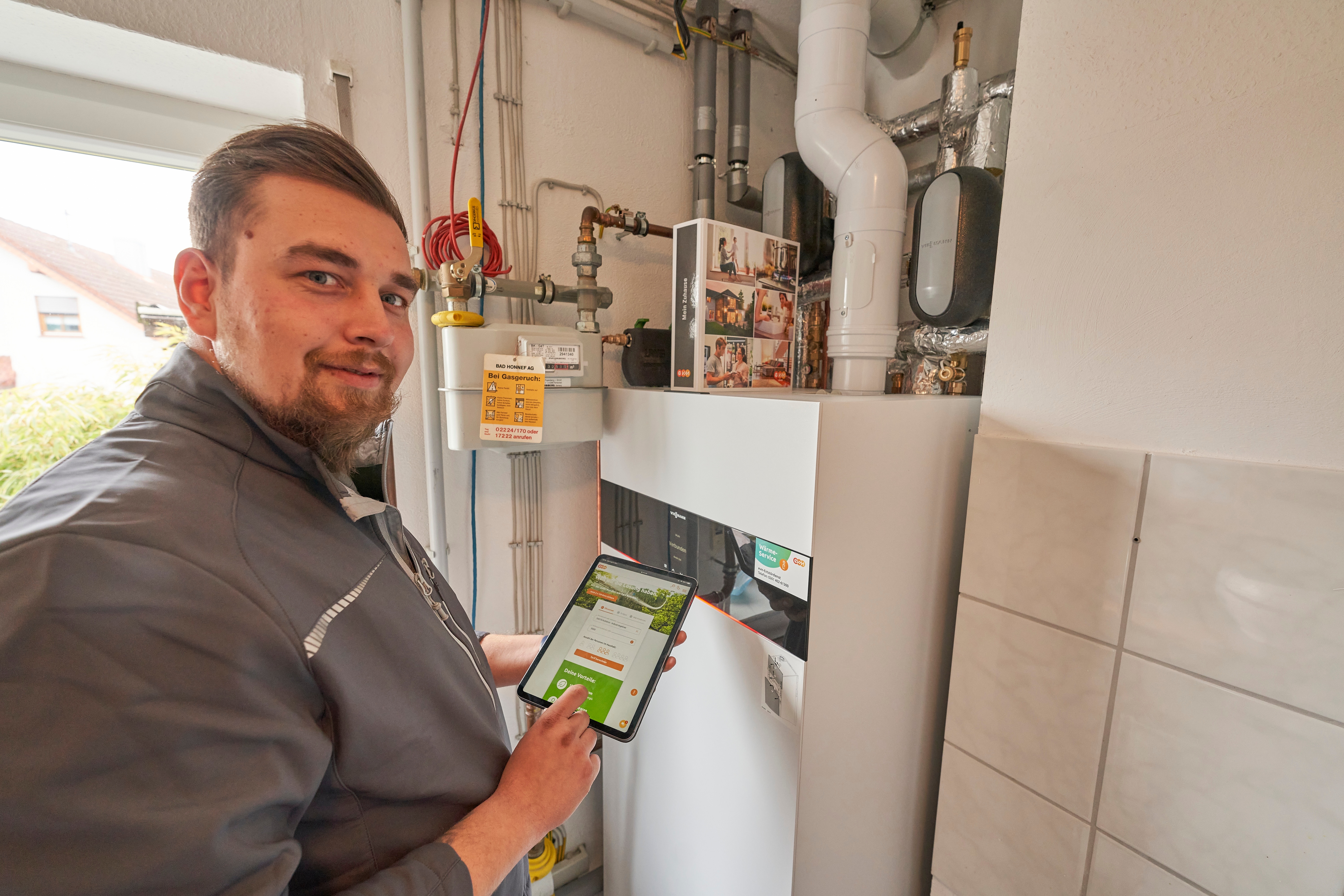 Professionelles Handwerk für Dein Zuhause: Mit der evm Service GmbH Ein Monteur der evms steht vor der neu eingebauten Heizungsanlage
