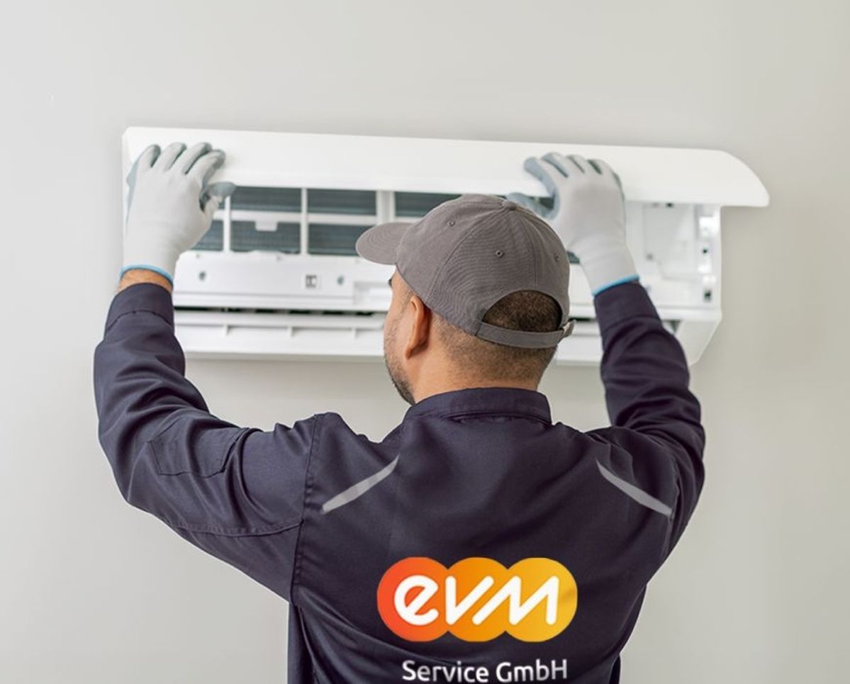 Ein Monteur der evm Service GmbH arbeitet an einer Klimaanlage