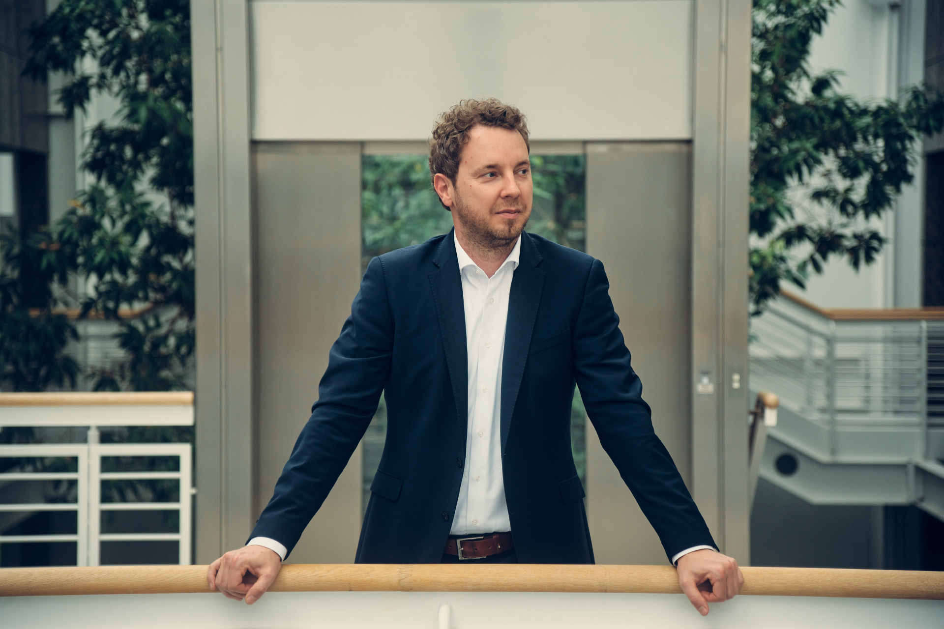 Christoph Hesse zum Koalitionsvertrag Vorstand der evm, Christoph Hesse, steht vor einem Geländer und blickt zum rechten Bildrand.